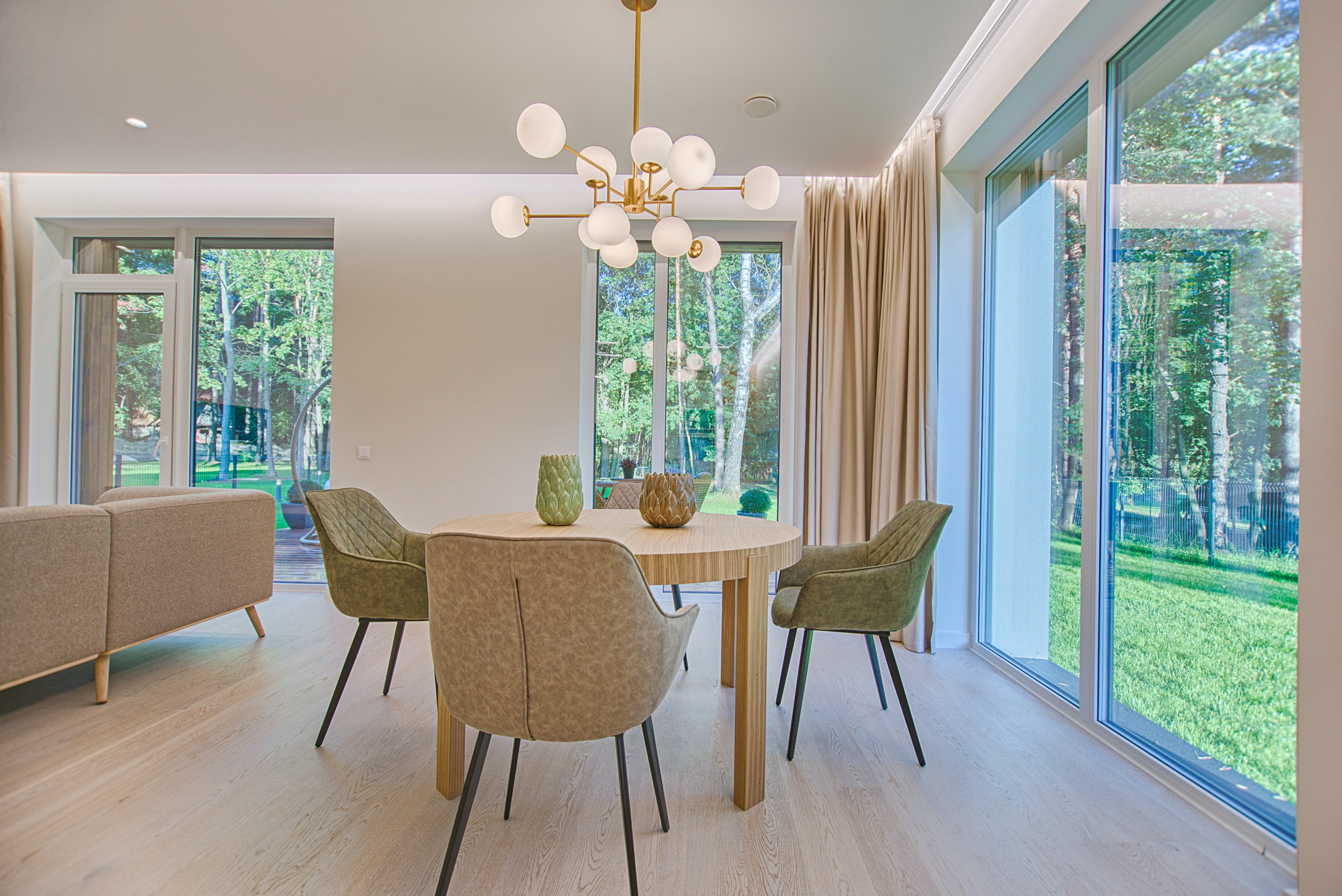 Living room with table, chairs & floor to ceiling windows.